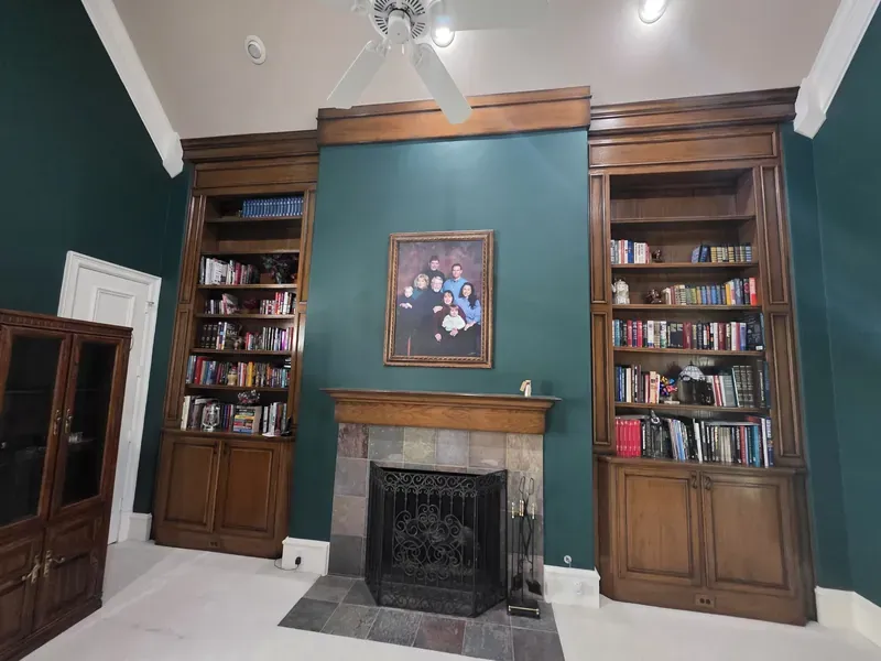 Library painted deep green around built-in bookshelves and fireplace — Collin County, TX | Collin County Handyman Company